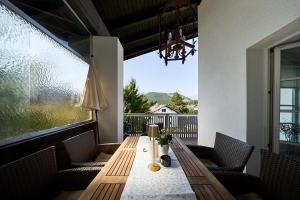 a porch with a wooden table and chairs at Bergkranz Apartments in Seefeld in Tirol