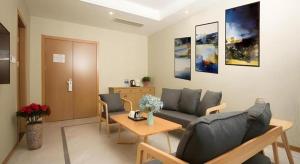 a living room with a couch and a table at Shell Changzhou Yangrong City Hotel in Changzhou