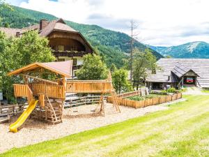 a playground in front of a house with a slide at Hotel Gasthof Hinteregger in Bad Kleinkirchheim