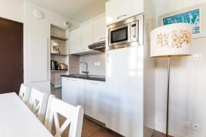 a kitchen with white cabinets and a microwave at Maya - Piscine - Calme - Parking in Baden