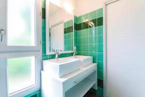 a bathroom with a sink and a mirror at Maya - Piscine - Calme - Parking in Baden