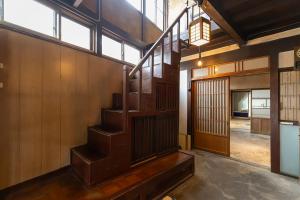 a staircase in a room with wooden walls and windows at Gujo BASE in Gujo