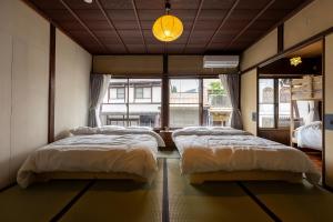 a bedroom with two beds and a large window at Gujo BASE in Gujo