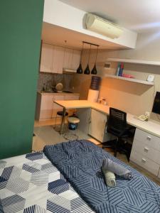 a room with a bed and a desk and a kitchen at Student park Apartment by ATA in Seturan +5 photos