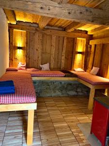 two beds in a room with wooden walls at Ferienhaus Hederle in Elzach