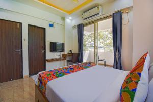 a bedroom with a large bed and a television at FabHotel Red Velvet Inn & Suites in Pune +18 photos