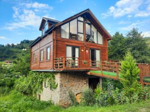 a wooden house on top of a stone building at Hanging Garden Holiday Home - Riverside in Ardeşen