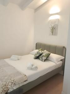 a bed with white sheets and pillows in a room at Villa Cormorani 1 in Golfo Aranci