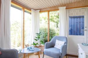 a living room with two chairs and a table at 16608-1-Farevejle-Horager-8 in Kårup +15 photos