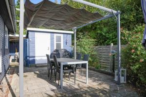 a patio with a table and chairs under a canopy at 16608-1-Farevejle-Horager-8 in Kårup