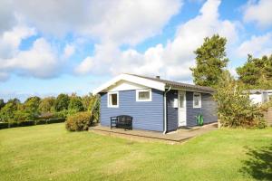 a small blue house with a deck in a yard at 16608-1-Farevejle-Horager-8 in Kårup