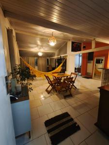a room with a table and chairs and a hammock at Casa aconchegante em área verde in Niterói