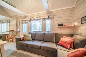 a living room with a couch and some windows at Lavi Chalet by Aavalevi in Levi