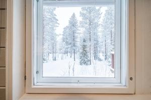 a window in a room with snow covered trees at Lavi Chalet by Aavalevi in Levi +29 photos