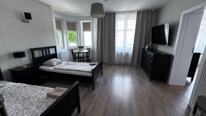 a living room with two beds and a television at Belgard- House 32 in Białogard