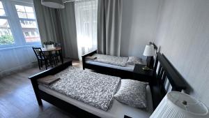a bedroom with two beds and a table and a window at Belgard- House 32 in Białogard +16 photos
