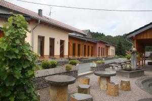 einen Innenhof eines Gebäudes mit Tischen und Stühlen in der Unterkunft Bistro im Ring in Quiddelbach