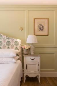 a bedroom with a bed and a table with a lamp at Despotiko Hotel in Mikonos