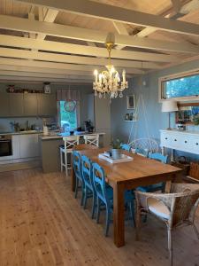 Una cocina y un comedor con mesa y sillas de madera. en Cozy and spacious vacation house by the sea, en Kemiönsaari