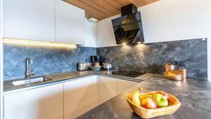 a kitchen with a bowl of fruit on a counter at ASAI210-5-2 Appartement-4 étoiles Les Saisies - 6 personnes in Les Saisies