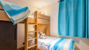 a bedroom with bunk beds with a teddy bear on a bed at ASAI210-7-1 Appartement 4 étoiles - Les Saisies - 8 personnes in Les Saisies
