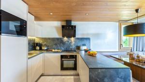 a kitchen with white cabinets and a black counter top at ASAI210-7-1 Appartement 4 étoiles - Les Saisies - 8 personnes in Les Saisies