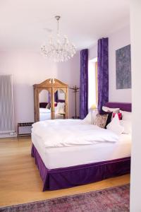Un dormitorio con una cama grande y una lámpara de araña. en Gästehaus im Weingut am Nil, en Kallstadt