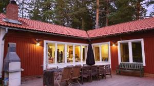 Casa con patio con mesa y sombrilla en Spersboda 2 barnvänliga hus sjöutsikt & VARM pool Spersboda, en Spersboda