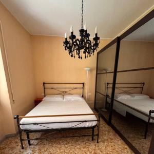 una camera da letto con due letti e un lampadario di Colle Aurelio Home a Roma