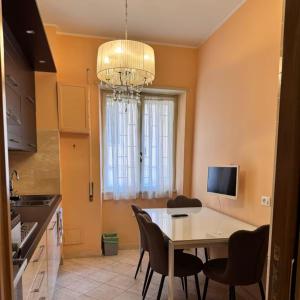 una cucina con tavolo, sedie e lampadario pendente di Colle Aurelio Home a Roma