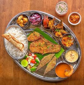 a tray of food with fish rice and other foods at Khushi Waves in Arpora