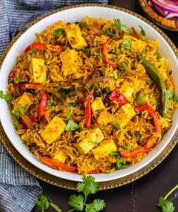 a bowl of rice with tofu and vegetables on a table at Khushi Waves in Arpora +4 photos