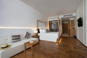 una camera d'albergo con un letto e un divano di Patong Beach Hotel by See2Sea a Patong Beach