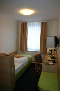 a hotel room with a bed and a desk and a window at Gasthof Dittmannsdorf in Olbernhau