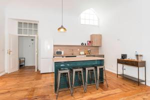 a kitchen with a counter and stools in it at CICIOSO flats João de Deus 1 in Évora +6 photos