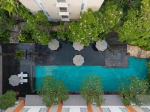 an overhead view of a swimming pool with trees at HARRIS Hotel & Residences Sunset Road in Kuta