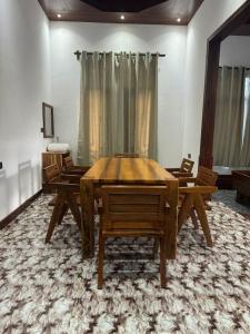 una sala da pranzo con tavolo e sedie in legno di Villa Flower Zanzibar a Kiwengwa
