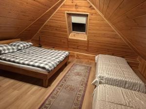a room with two beds and a window in a cabin at Pokoje Gościnne u Grażyny in Ojców