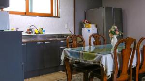 a kitchen with a table and chairs and a refrigerator at Blue Sea Pension 