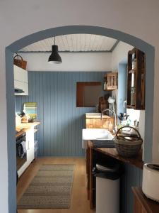 a kitchen with a sink and a blue wall at Die Alm in Schöllbüchl, Privatzimmer in St. Martin