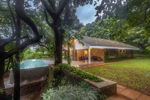 a house with a swimming pool in a yard at SaffronStays Hidden Branches -3BR pet-friendly villa with infinity pool & forest views in Khandala in Lonavala