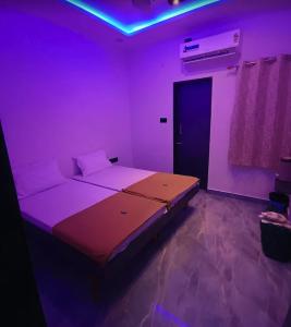 a bedroom with a large bed in a purple room at Maghudiya Homestay in Dwarka