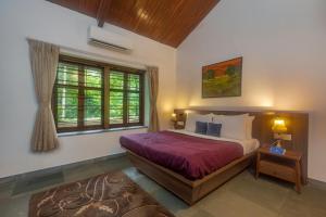 a bedroom with a bed and a window at SaffronStays Hidden Branches -3BR pet-friendly villa with infinity pool & forest views in Khandala in Lonavala