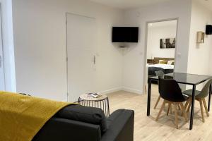 a living room with a couch and a table at L'Aligoté - Appartement en coeur de ville By Primo in Sennecey-le-Grand