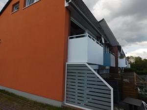 uma casa laranja com uma varanda branca em Ferienwohnung Kapitein em Hooksiel