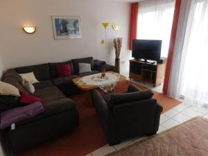 uma sala de estar com um sofá e uma mesa em Ferienwohnung Kapitein em Hooksiel