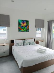 a bedroom with a bed and a painting on the wall at Tranquility in Bangrak Beach