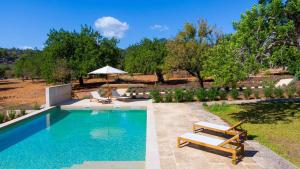 a swimming pool with a bench and an umbrella at Empaltada in Selva