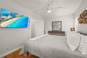 a bedroom with a bed and a tv on the wall at Condo by the Beach King Bed Lush Patio w BBQ Breakers Key Seven H0MES in Fort Lauderdale
