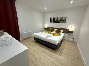 a bedroom with a bed with yellow pillows on it at L'Aligoté - Appartement en coeur de ville By Primo in Sennecey-le-Grand